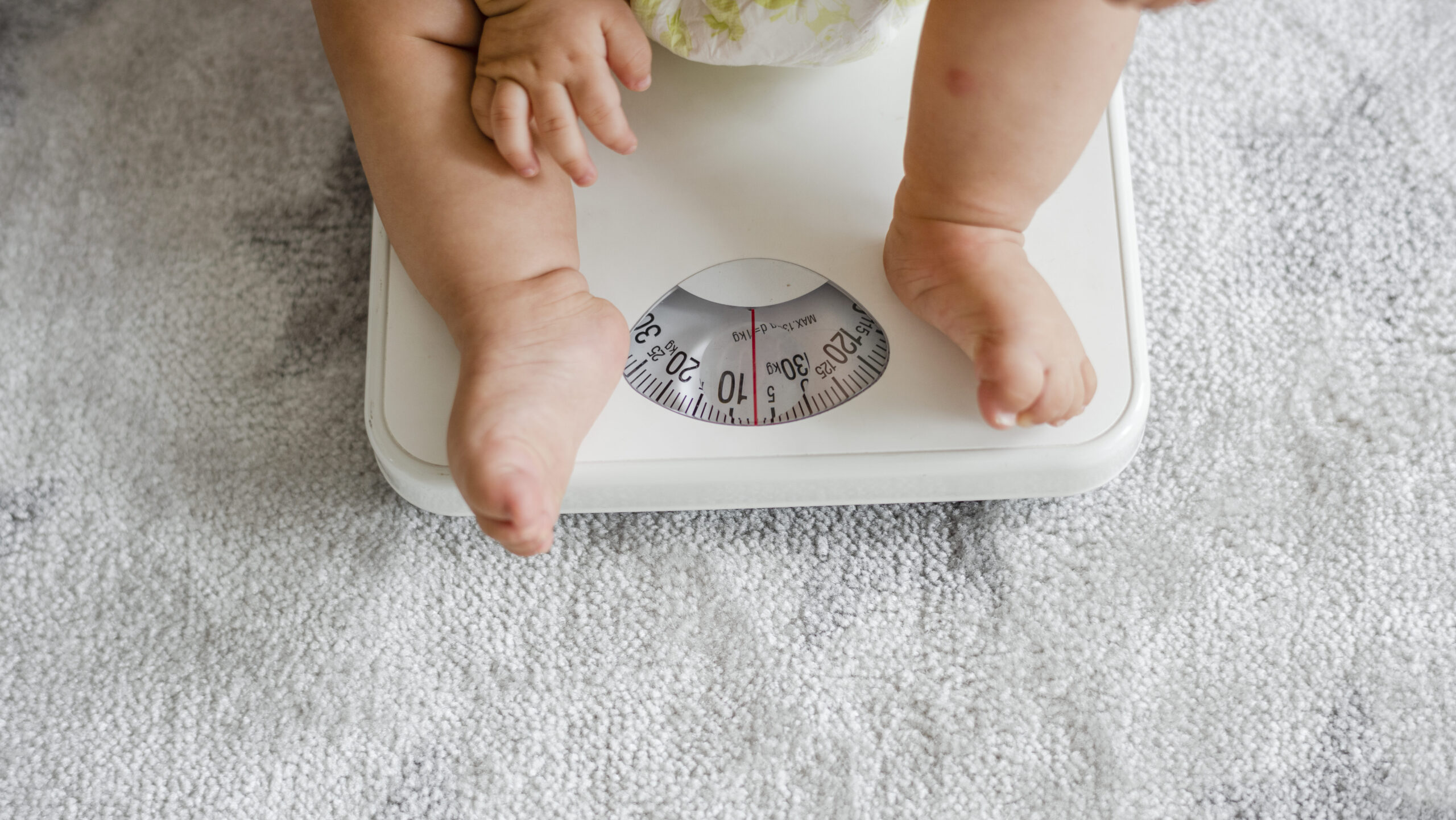 Balança Ideal para Pesar o seu Bebê em 2025 5 closeup de um bebe pernas ligado um pesando escala edited scaled