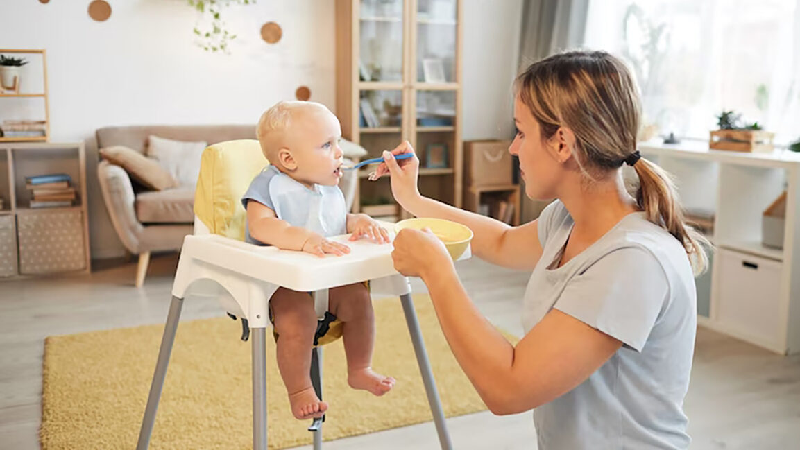 Cadeira de Alimentação: Escolhendo a Melhor para o Seu Bebê em 2025 2 mulher adulta moderna alimentando seu filho bebe alegre com mingau na sala de estar em casa 236854 2 edited