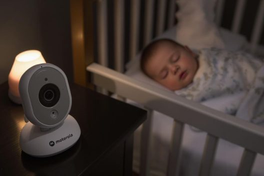 Bebê dormindo tranquilamente no berço com babá eletrônica Motorola