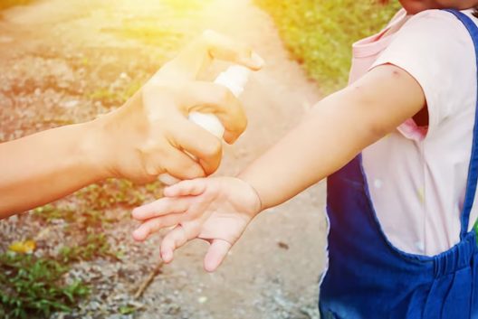 mae que pulveriza repelentes de insetos ou mosquitos na pele da menina repelente para bebe